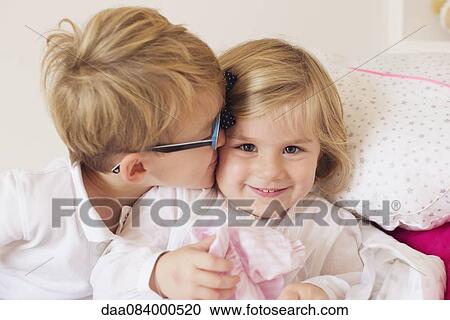 Boy kissing little sister's cheek View Large Photo Image Stock Image - Boy kissing little sister's cheek. Fotosearch