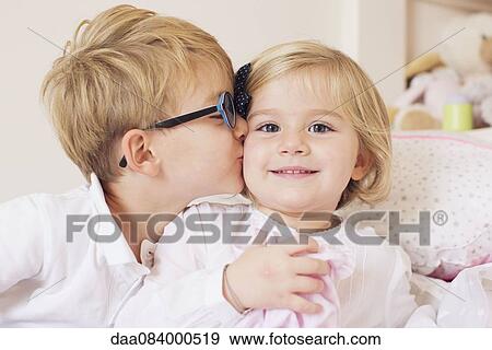 Boy kissing sister's cheek View Large Photo Image Stock Photo - Boy kissing sister's cheek. Fotosearch