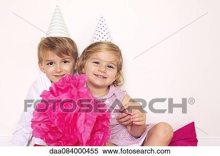 Stock Photography - Brother and sister at birthday party, portrait. Fotosearch