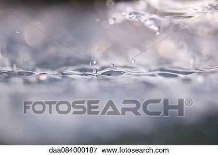 Close-up of drops splashing on water surface View Large Photo Image Stock Photo - Close-up of drops splashing on water surface. Fotosearch