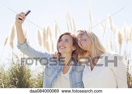 Stock Photo - Couple capturing moment with selfie. Fotosearch