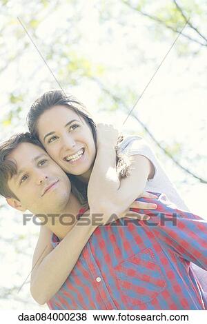 Stock Photo - Couple embracing outdoors, portrait. Fotosearch