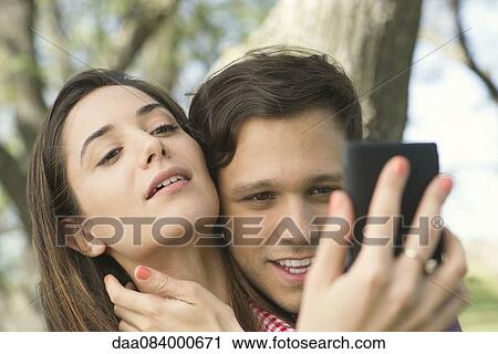 Stock Image - Couple posing for selfie outdoors. Fotosearch