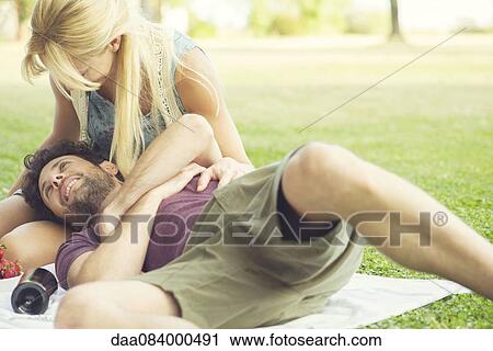 Couple relaxing together at park View Large Photo Image Stock Image - Couple relaxing together at park. Fotosearch
