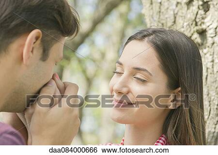 Couple together outdoors, man kissing woman's hand View Large Photo Image Stock Photograph - Couple together outdoors, man kissing woman's hand. Fotosearch