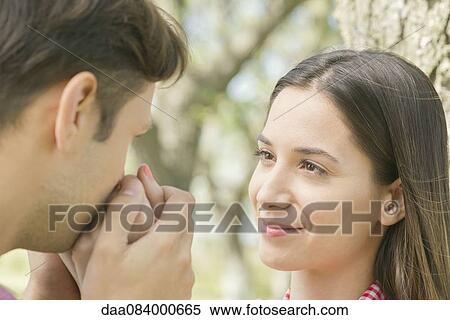 Couple together outdoors, man kissing woman's hand View Large Photo Image Stock Photography - Couple together outdoors, man kissing woman's hand. Fotosearch