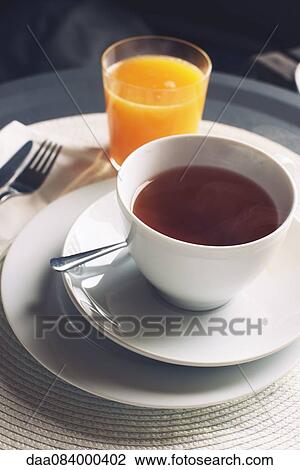 Cup of hot tea and glass of orange juice View Large Photo Image Stock Image - Cup of hot tea and glass of orange juice. Fotosearch