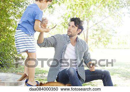 Stock Image - Father giving son helping hand. Fotosearch