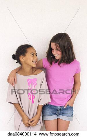 Picture - Girl standing with arm around friend's shoulder. Fotosearch