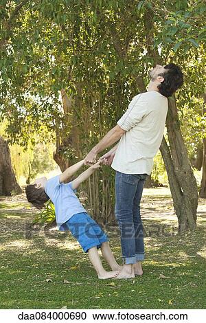 Stock Image - Little boy and father bonding outdoors. Fotosearch
