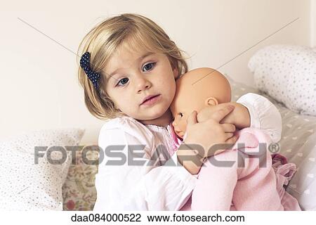 Stock Image - Little girl hugging doll. Fotosearch