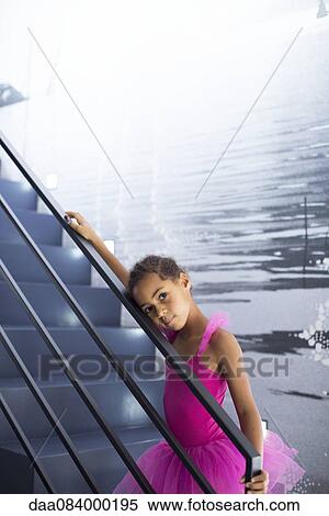 Stock Photography - Little girl in ballerina costume leaning against staircase railing. Fotosearch