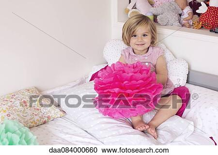 Stock Image - Little girl in her bedroom. Fotosearch