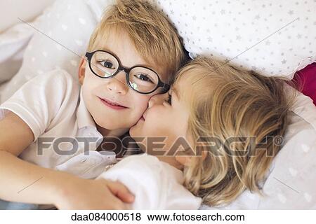 Stock Photo - Little girl kissing big brother. Fotosearch