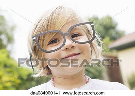 Stock Image - Little girl wearing costume glasses. Fotosearch