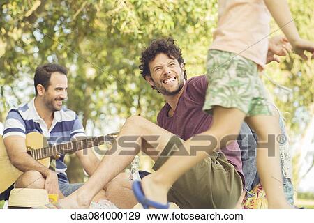 Stock Photo - Man at picnic watching children play. Fotosearch