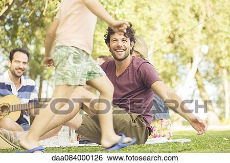 Man at picnic watching children play View Large Photo Image Stock Photograph - Man at picnic watching children play. Fotosearch