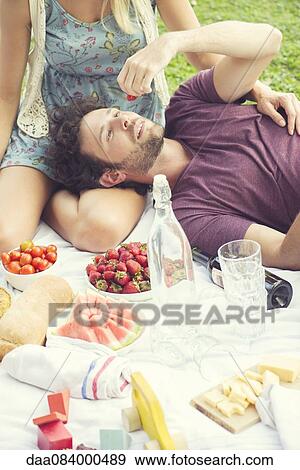 Stock Photo - Man enjoying picnic with companion. Fotosearch