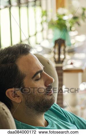 Stock Image - Man napping in armchair. Fotosearch