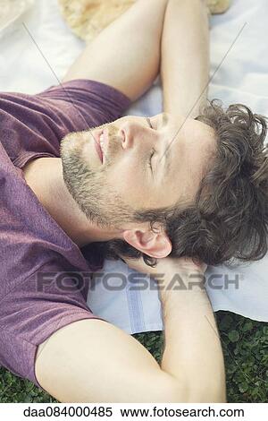 Stock Photography - Man napping outdoors. Fotosearch