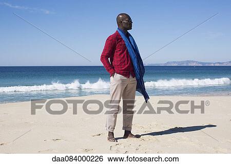 Man standing alone on beach View Large Photo Image Stock Photograph - Man standing alone on beach. Fotosearch