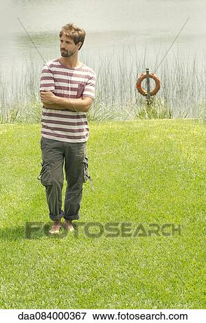 Man standing in front of lake View Large Photo Image Stock Photo - Man standing in front of lake. Fotosearch