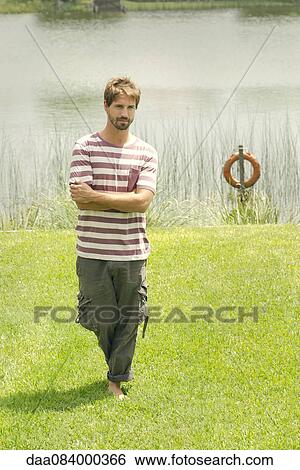 Man standing in front of lake View Large Photo Image Stock Photograph - Man standing in front of lake. Fotosearch