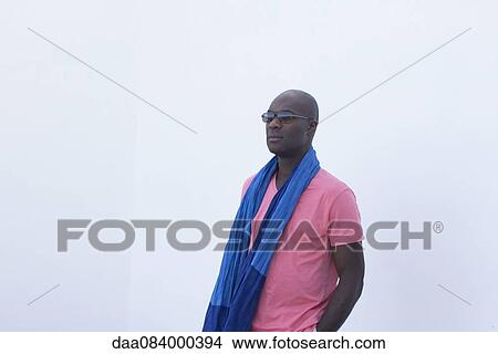 Man wearing scarf and sunglasses, looking away in thought View Large Photo Image Picture - Man wearing scarf and sunglasses, looking away in thought. Fotosearch