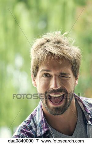 Man winking playfully, portrait View Large Photo Image Stock Photo - Man winking playfully, portrait. Fotosearch