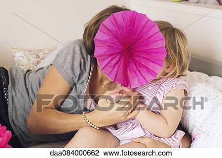 Mother and daughter hiding behind tissue paper flower View Large Photo Image Stock Image - Mother and daughter hiding behind tissue paper flower. Fotosearch