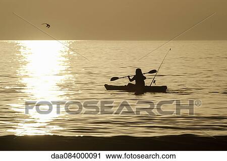 Person kayaking at sunset View Large Photo Image Stock Image - Person kayaking at sunset. Fotosearch