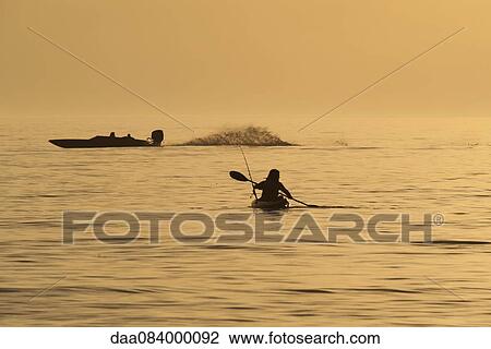Person kayaking at sunset View Large Photo Image Stock Image - Person kayaking at sunset. Fotosearch