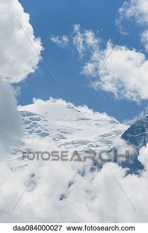 Snow-covered mountains surrounded by clouds View Large Photo Image Stock Photo - Snow-covered mountains surrounded by clouds. Fotosearch