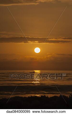 Tranquil sunset over the sea with person fishing in the distance View Large Photo Image Stock Photography - Tranquil sunset over the sea with person fishing in the distance. Fotosearch