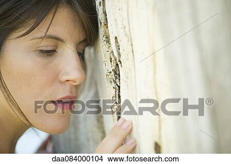 Woman leaning against tree trunk, portrait View Large Photo Image Picture - Woman leaning against tree trunk, portrait. Fotosearch