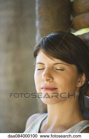 Woman leaning against wall with eyes closed, portrait View Large Photo Image Stock Image - Woman leaning against wall with eyes closed, portrait. Fotosearch