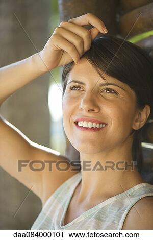 Stock Image - Woman looking up dreamily, portrait. Fotosearch