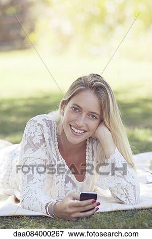 Stock Photo - Woman lounging in park, portrait. Fotosearch