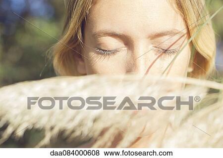Stock Photo - Woman partially obscured by tall grass. Fotosearch