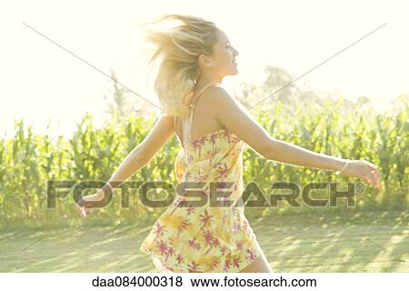 Stock Photo - Woman running across open field. Fotosearch