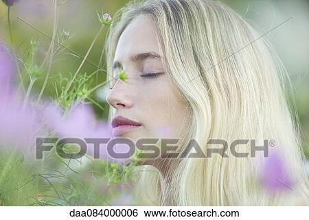 Stock Photograph - Woman smelling flowers. Fotosearch