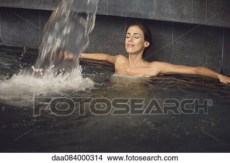 Picture - Woman soaking in spa pool. Fotosearch