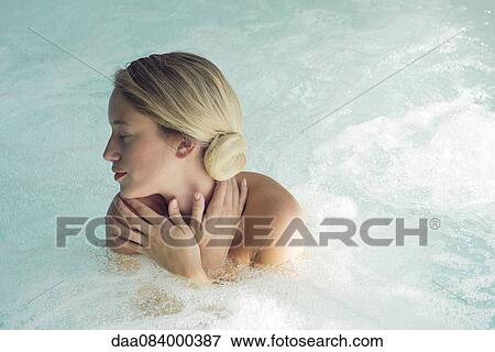 Stock Photo - Woman soaking in spa pool. Fotosearch