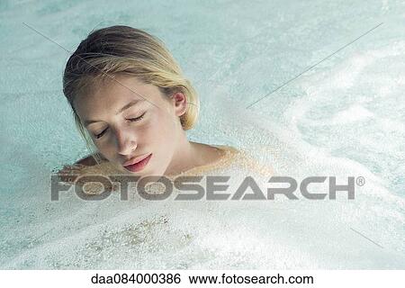 Stock Photograph - Woman soaking in spa pool. Fotosearch