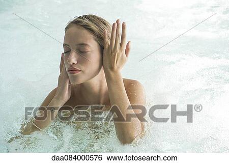 Stock Photograph - Woman soaking in spa pool. Fotosearch