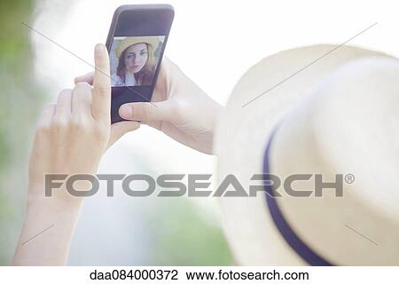 Woman taking selfie with smartphone View Large Photo Image Stock Image - Woman taking selfie with smartphone. Fotosearch