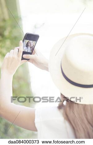 Woman taking selfie with smartphone View Large Photo Image Stock Image - Woman taking selfie with smartphone. Fotosearch