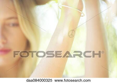 Woman with peace sign tattoo View Large Photo Image Stock Photography - Woman with peace sign tattoo. Fotosearch