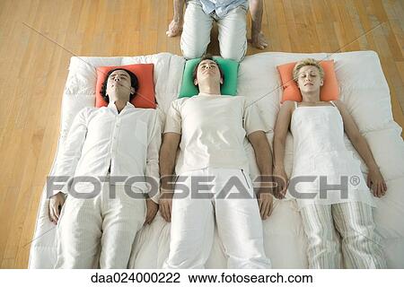 Alternative therapy session, three adults lying side by side while therapist kneels nearby, cropped View Large Photo Image Stock Image - Alternative therapy session, three adults lying side by side while therapist kneels nearby, cropped. Fotosearch