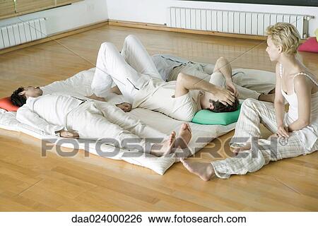 Alternative therapy session, three adults lying side by side while therapist sits nearby View Large Photo Image Stock Photograph - Alternative therapy session, three adults lying side by side while therapist sits nearby. Fotosearch